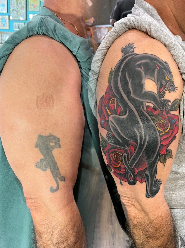 Large dark dragon tattoo on the thigh with a small silhouette nearby.
