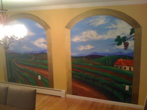 Wall mural of green fields and hills beneath arches and blue skies.