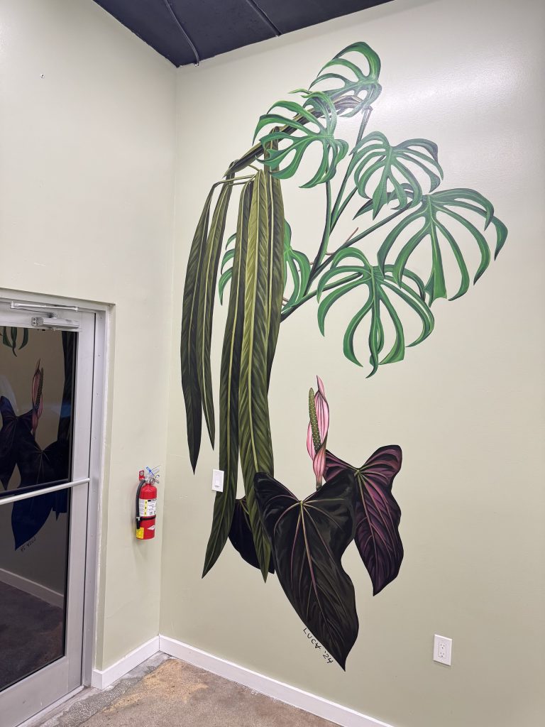 Tropical plant mural with long green leaves and dark foliage.