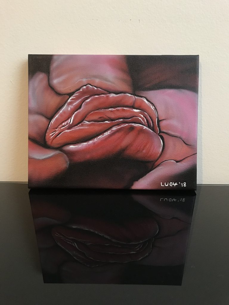 Framed painting of parted lips reflected on a glossy surface.